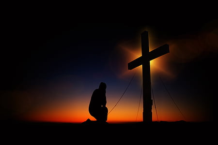 silhouette of man kneeling in front of a cross thumbnail
