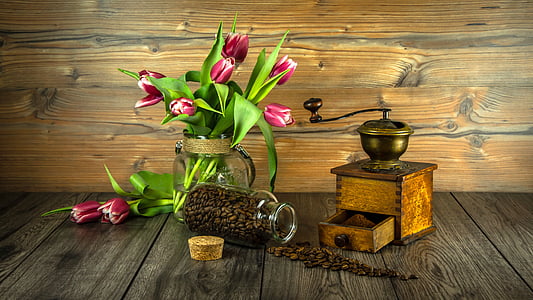 pink flowers beside brown wooden manual coffee grinder thumbnail