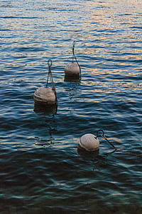 three buoys on body of water thumbnail