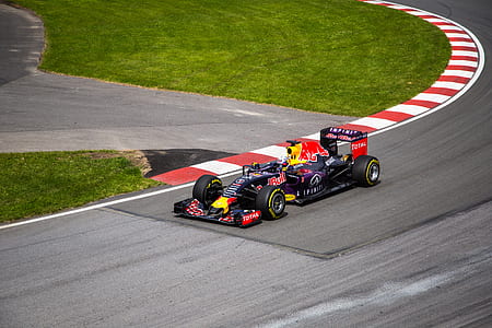 black, blue, and red F1 on road at daytime thumbnail