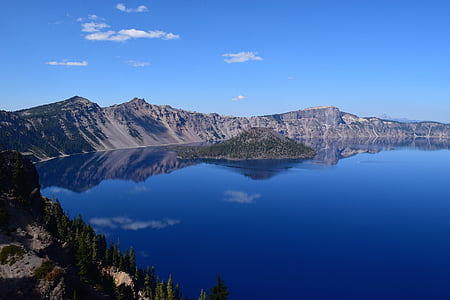 calm body of lake surrounded with mountains thumbnail