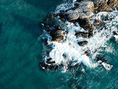 aerial photography of sea wave near rock thumbnail