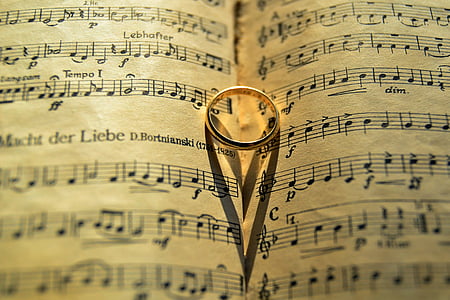 gold-colored band ring on opened musical book thumbnail