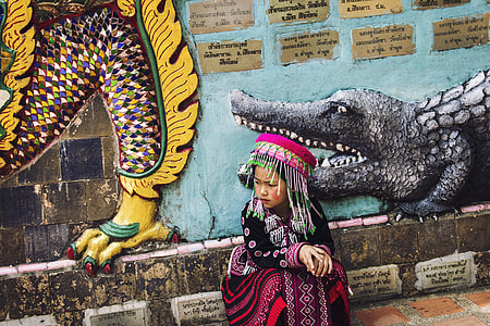 girl sitting near painted wall taken during daytime thumbnail