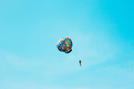 person hanging hot air balloon surrounded blue sky thumbnail