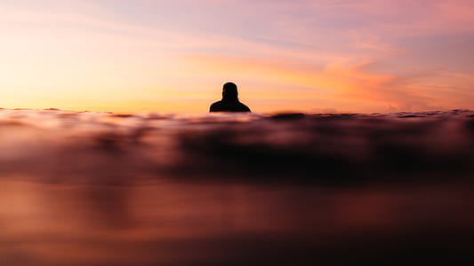 silhouette of person standing under cloudy sky during daytime thumbnail