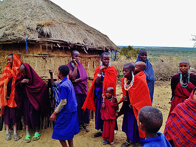 people standing near brown hut at daytime thumbnail