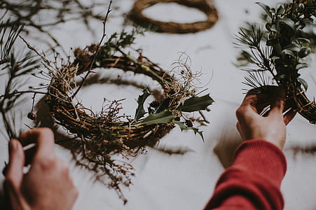 person holding green and brown wreath thumbnail