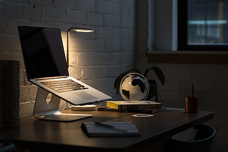 Macbook Pro on Stand Beside Desk Globe thumbnail
