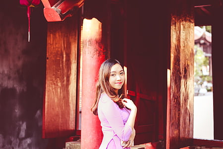 woman wearing pink 3/4-sleeved shirt standing near brown wall thumbnail