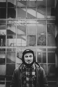 grayscale photography of man wearing hoodie and cap thumbnail