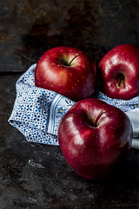 three red apples on blue floral textile thumbnail