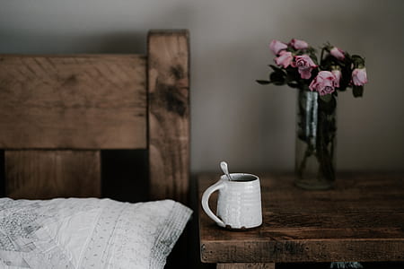 round white ceramic mug on corner of brown nightstand thumbnail