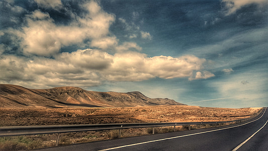road beside desert under clear blue skies thumbnail