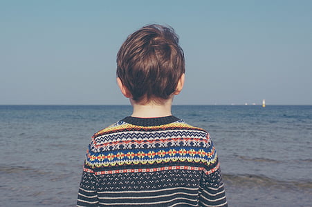 boy facing sea under blue calm sky thumbnail