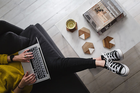 Young woman sitting on the sofa and working on her laptop thumbnail