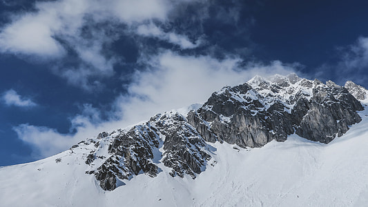 snow-covered mountain under cloudy blue sky during daytime thumbnail