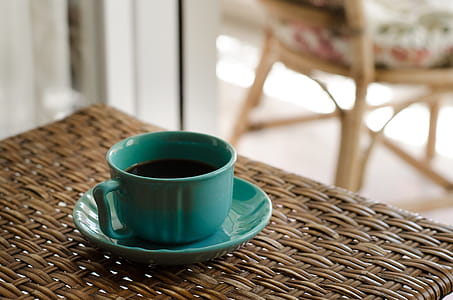 Blue Coffee Cup With Saucer Filled With Coffee on Top of Wicker Table thumbnail
