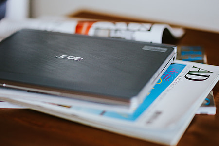 Laptop, a smartphone, magazines and cups of coffee on a table thumbnail