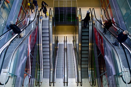 people riding on a escalator inside a buildings thumbnail