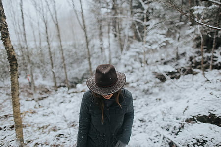 person standing in the middle on snow field surrounded by trees thumbnail