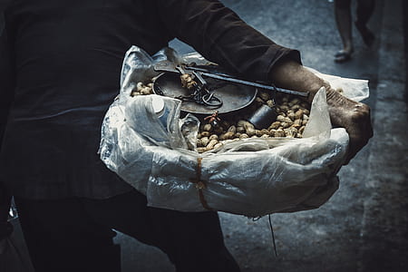 person holding basket with peanuts during daytime selective focus photography thumbnail