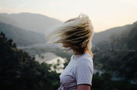 woman wearing white shirt standing on cliff during day time thumbnail