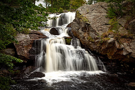 raging waterfalls beside rock formation thumbnail