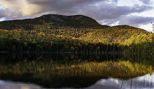 mirror photography of calm body of water and mountain thumbnail