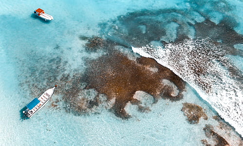 aerial photo of blue and white boat sailing on large body of water during daytime thumbnail