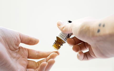 person holding brown glass bottle thumbnail