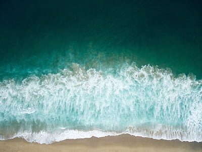 aerial photography of green seashore with crushing waves during daytime thumbnail