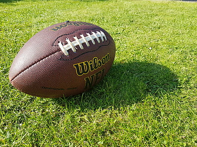 brown Wilson football on green grasses during daytime thumbnail