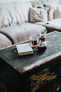 clear drinking glasses beside white book on green ammunition box thumbnail