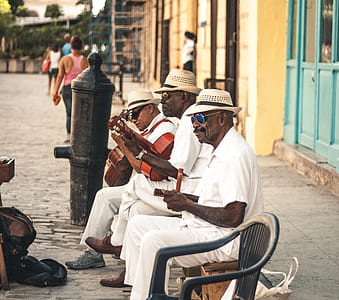 three men sitting on bench playing music thumbnail