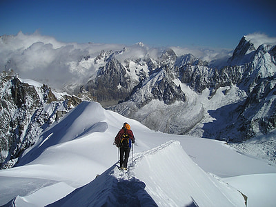 person walking on ice covered path on mountain pass during daytime thumbnail