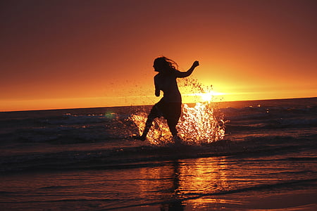 silhouette of woman standing on seashore thumbnail