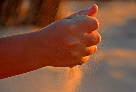 selective focus shot of person grasping sand thumbnail