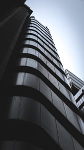low angle grayscale photo of high rise city buildings thumbnail