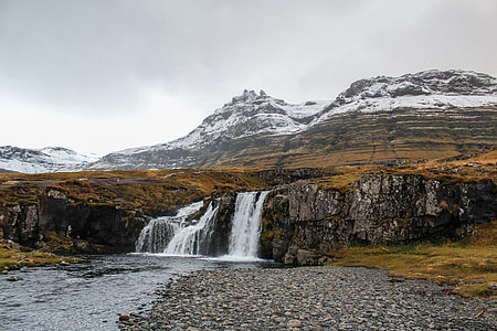 water falls on gray mountain under gray clouded sky thumbnail