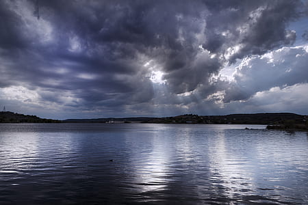 body of water under gray and white sky durign daytime thumbnail