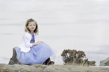 girl wearing purple dress and white blazer sitting on wood during daytime thumbnail
