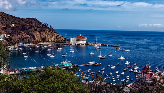 sailboats near building and hill thumbnail
