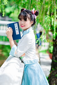 woman holding book on concrete balustrade thumbnail