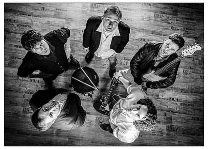 grayscale photography of five man looking up holding guitars and drum thumbnail