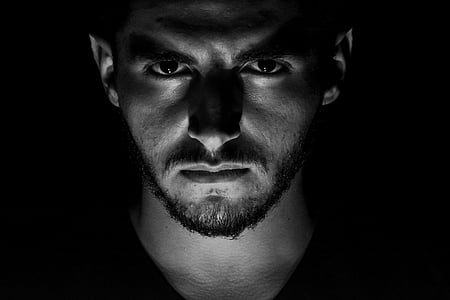 man under lighted gray scale photo thumbnail