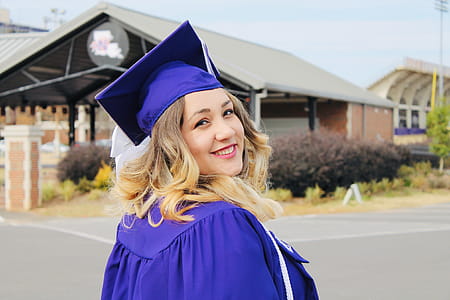 Woman Wearing Purple Mortar Board and Academic Robe thumbnail