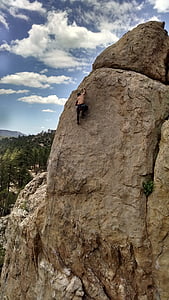 man climbing on rock formation thumbnail