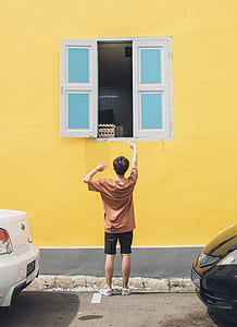 person standing in front of window during daytime thumbnail