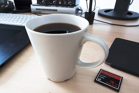white ceramic mug filled with coffee on table thumbnail